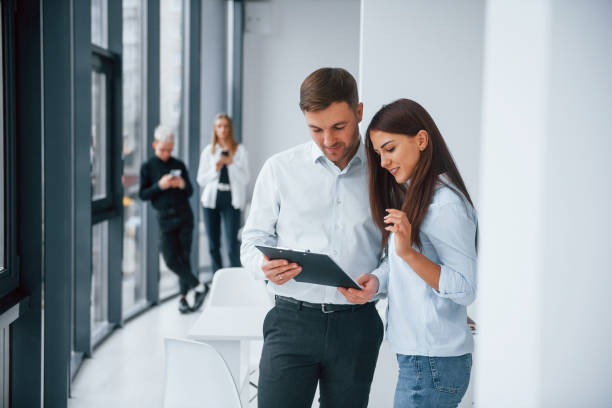 istock Woman and man talking about documents in front of young successful team that working and communicating together indoors in office 1323865566