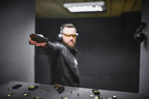Bearded Gangster Handling Weapon Improperly On Range