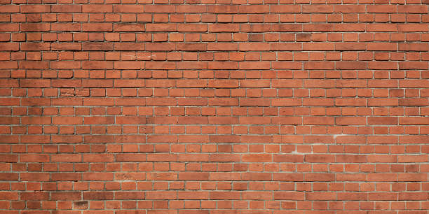 istock Panoramic view of grunge weathered red brick wall texture background 1323867144