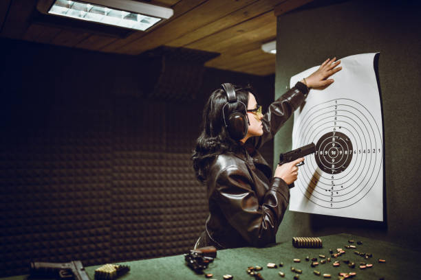 istock Female Spreading Paper Target On Shooting Range to Check Results 1323867302