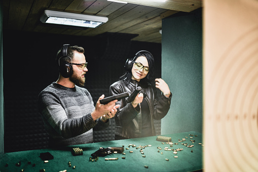 Male Shooting Instructor Teaching Female The Basics Of Firearm Handling
