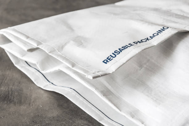 istock Reusable bag used by online shops for shipping. Postage for sending it back is paid by the shop. Concept for recycling and sustainability. Gray concrete background. 1323868920