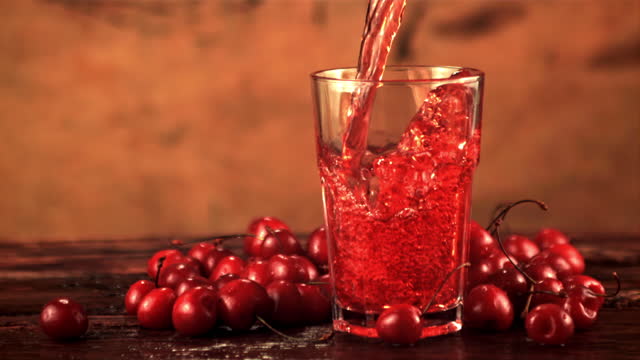 Super slow motion in the glass pour cherry juice whirlpool with splashes. Filmed on a high-speed camera at 1000 fps.