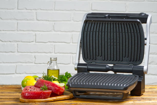istock raw tuna steaks cooking on electric grill. 1323874509