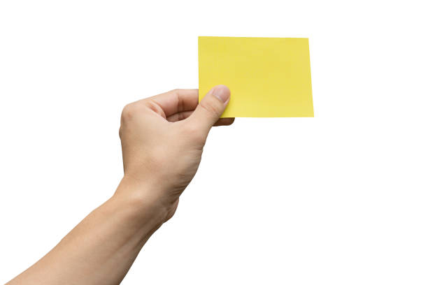 istock Hand holding yellow paper isolated on white 1323874691