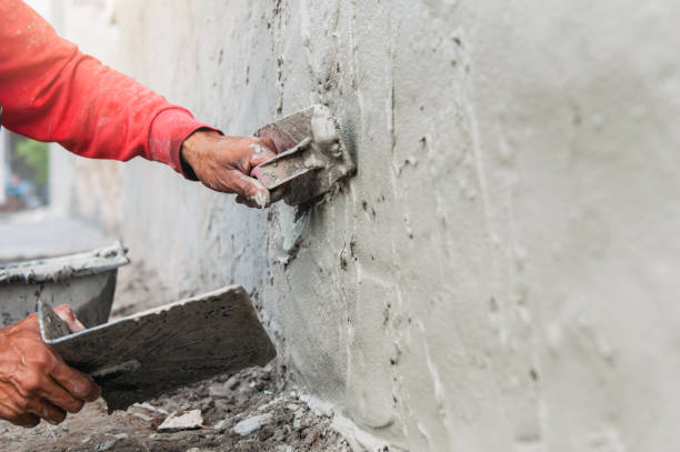 istock hand of worker plastering cement at wall for building house in construction site 1323879365