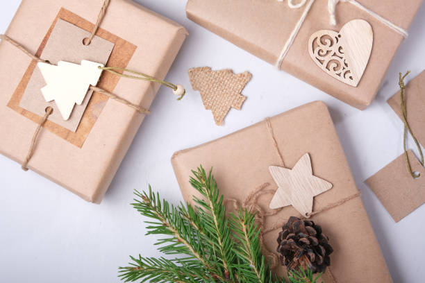 istock several gift boxes packed in eco paper, natural decorations for DIY gifts, fir branches, cones and wooden figurines for decor, top view, gray background, zero waste lifestyle 1323880817