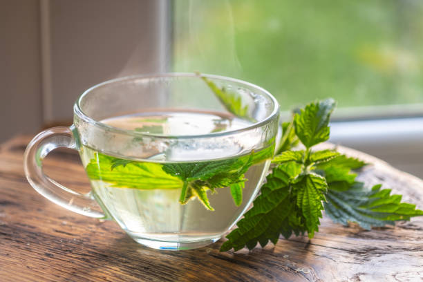 istock Transparent cup with nettle tea. fresh nettle on a wooden board 1323881893