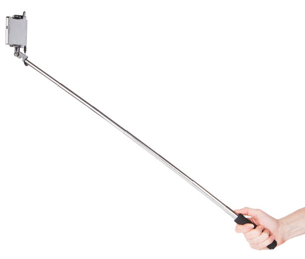 hand hält einen langen metall-selfie-stick - einbeinstativ stock-fotos und bilder