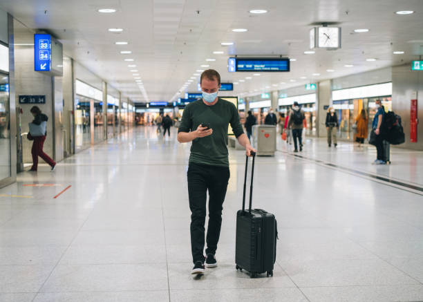 istock Young man texts on cellphone as he walks through train station 1323886269