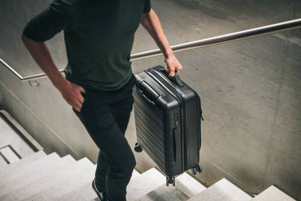 Young man walks up staircase through train station