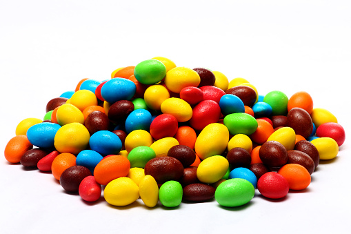 candy coated with rainbow-colored chocolates on the front and white background