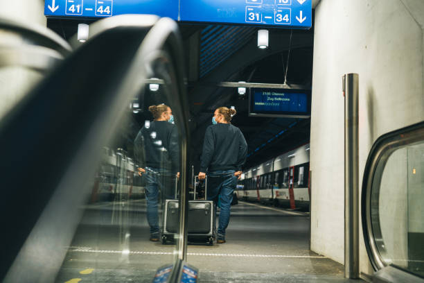 istock Young man walks through train station, towards his platform 1323887154