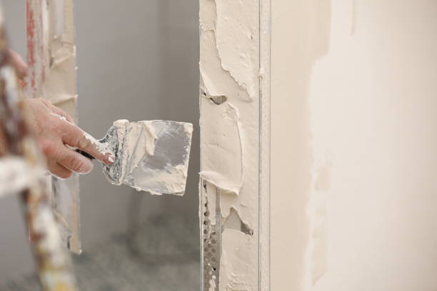 istock Builder using a trowel to add plaster. Plastering wall with putty-knife, close up image. Fixing wall surface and preparation for painting. construction work during quarantine 1323888934