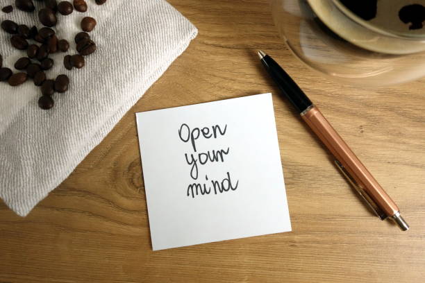 istock Open your mind text handwritten on sticky note with coffee and pen 1323890197