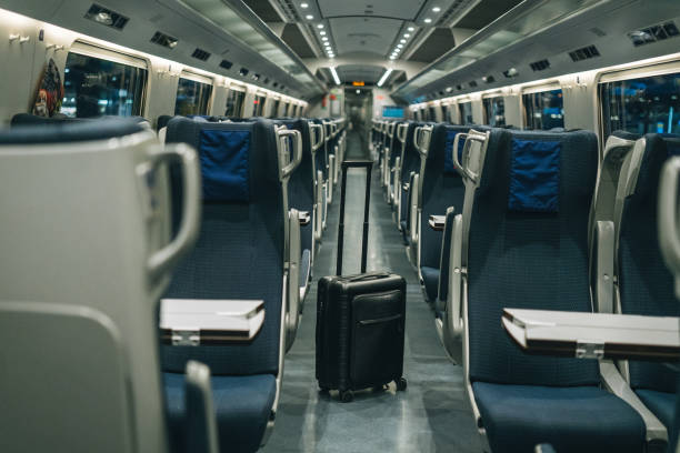 View down the aisles of seats in train Suitcase sits inside of the empty train train interior stock pictures, royalty-free photos & images