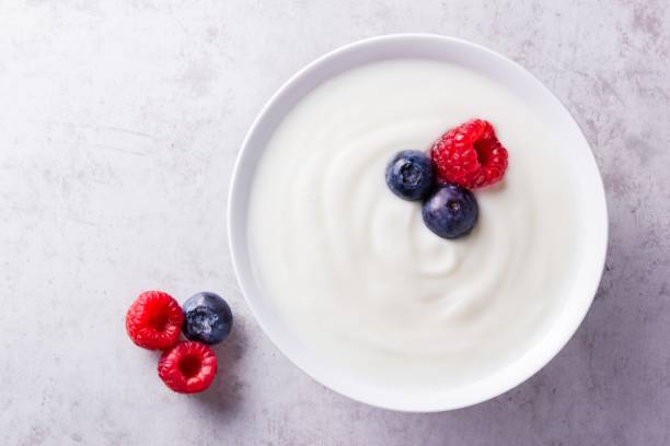 istock A white bowl with plain yogurt and some ripe blueberries and raspberries on grey countertop 1323892782
