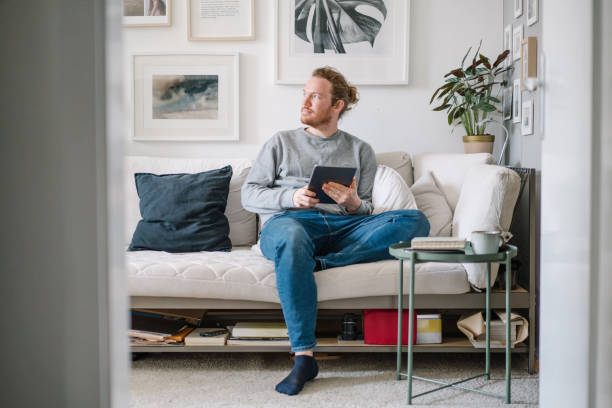 istock Young man works online from living room 1323895211