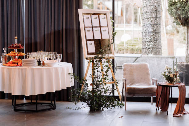 istock easel with wooden Stylish Board list seating plan for wedding reception. Vintage luxury wedding. table with fruit and champagne for guests 1323899252