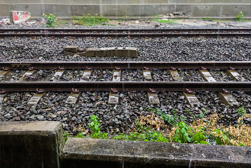 The double track of the railway line in the heavy rain after the storm near the urban station, front view for the copy space.
