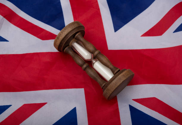 istock Waiting for UK visa concept with hourglass on Englad flag 1323902329