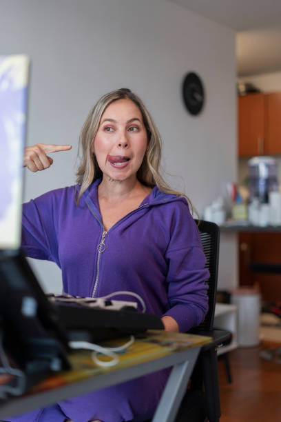 istock The singing teacher performs mouth and tongue exercises while giving her virtual singing classes wearing her pajamas from home. 1323904270