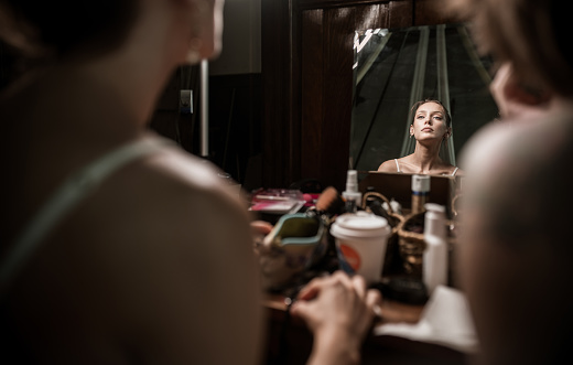Behind the scenes in Aerial Silk Studio: Female performers doing make up in front of the mirror before the practice performance.