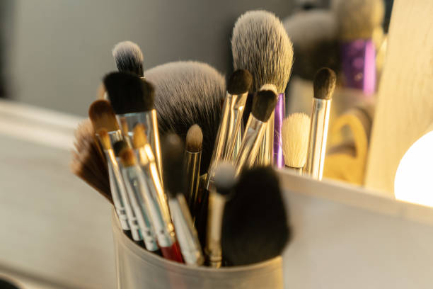 istock Many different makeup brushes stand on the makeup artist's desk in a round jar close-up, selective focus 1323907435