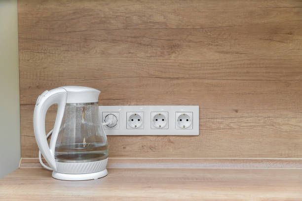 istock White transparent electric kettle with white cable in the socket on the kitchen table with copy space 1323908571