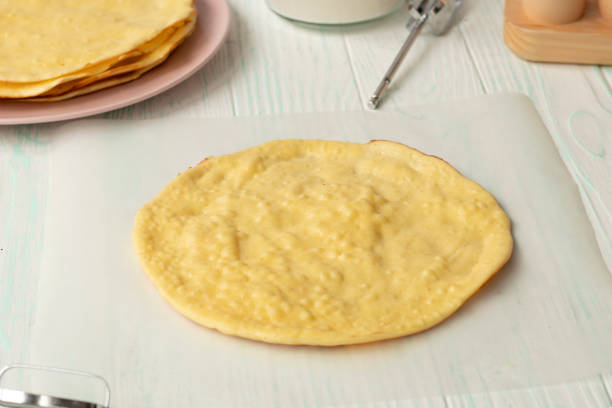 istock cake layers on baking parchment. The base of the cake on a wooden table. 1323908687