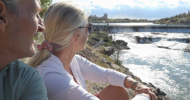 istock Mature couple watch look down river flowing from dam 1323909428