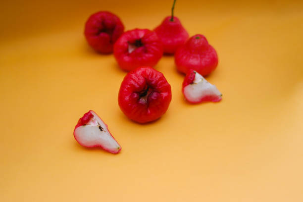 istock Freshly rose apple fruit isolated on orange background. Also known as jambu air Merah (Syzygium aqueum), jambu Semarang (Syzygium samarangense), Jambu Bol, or Malay Apple (Syzygium malaccense) 1323911626