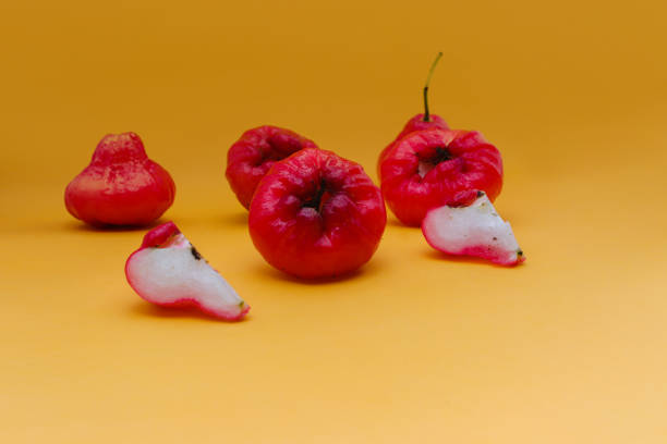 istock Freshly rose apple fruit isolated on orange background. Also known as jambu air Merah (Syzygium aqueum), jambu Semarang (Syzygium samarangense), Jambu Bol, or Malay Apple (Syzygium malaccense) 1323916947