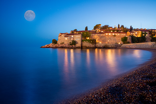 Sveti Stefan island near Budva on a beautiful summer night with moon. Montenegro, Balkans, Europe.
