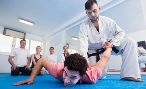 istock man training new taekwondo holds with adults during class 1323917109