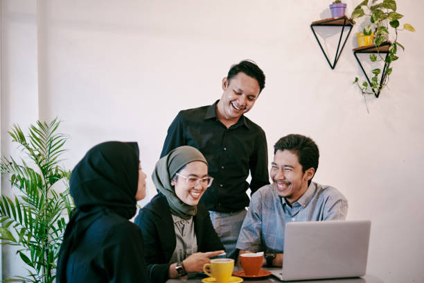 grupo de jovens discutindo no espaço de coworking moderno - etnia indonésia - fotografias e filmes do acervo