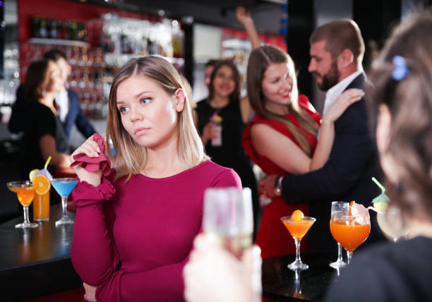 Woman offended while man dancing with another at nightclub Young woman offended while man dancing with another on party at nightclub vex nightclub stock pictures, royalty-free photos & images