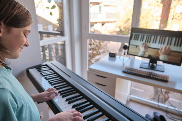 istock Homeschool European young boy learning piano from computer connecting to internet music online class by school teacher. New normal lifestyle and education, student study at home concept. 1323917365