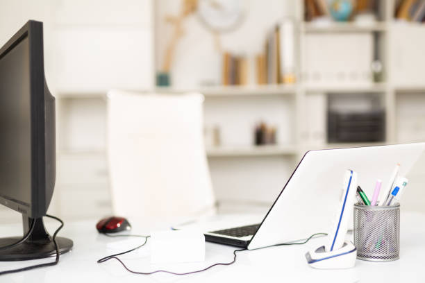 istock Office workplace for two with laptop and desktop computer monitor 1323918223