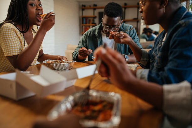 istock Young happy friends having fun during lunchtime at home 1323919101