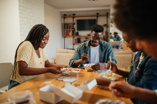 istock Young happy friends having fun during lunchtime at home 1323919103