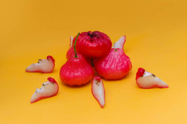 istock Freshly rose apple fruit isolated on orange background. Also known as jambu air Merah (Syzygium aqueum), jambu Semarang (Syzygium samarangense), Jambu Bol, or Malay Apple (Syzygium malaccense) 1323919996