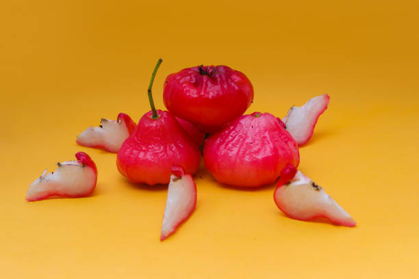 istock Freshly rose apple fruit isolated on orange background. Also known as jambu air Merah (Syzygium aqueum), jambu Semarang (Syzygium samarangense), Jambu Bol, or Malay Apple (Syzygium malaccense) 1323920305