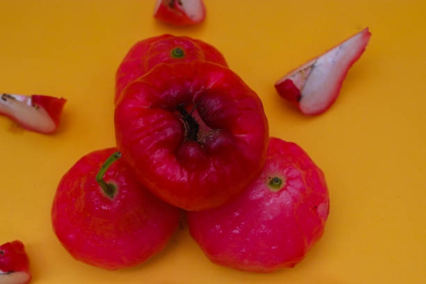 istock Freshly rose apple fruit isolated on orange background. Also known as jambu air Merah (Syzygium aqueum), jambu Semarang (Syzygium samarangense), Jambu Bol, or Malay Apple (Syzygium malaccense) 1323920459