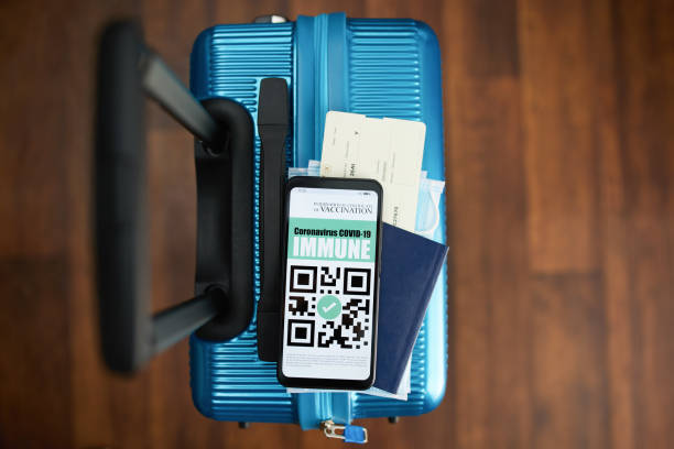 istock trolley bag with smartphone and covid passport app 1323921699