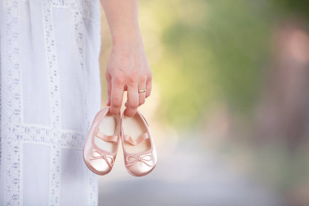 future parent holding a pair of unborn baby's little shoes - pair couple mid adult happiness imagens e fotografias de stock