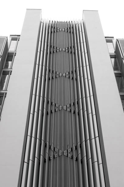 istock Black and white low angle view of modern office building, skyscrapers, white background with copy space 1323925126