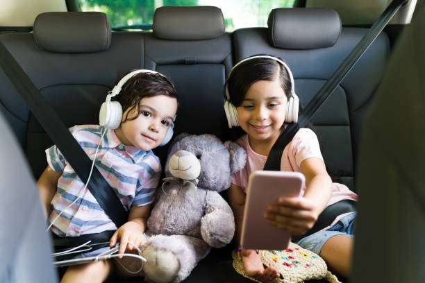 niños viendo un divertido video en un viaje por carretera - seat belt audio fotografías e imágenes de stock