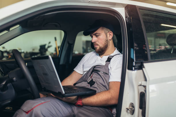 istock Professional car mechanic working in auto repair service using laptop. 1323927760