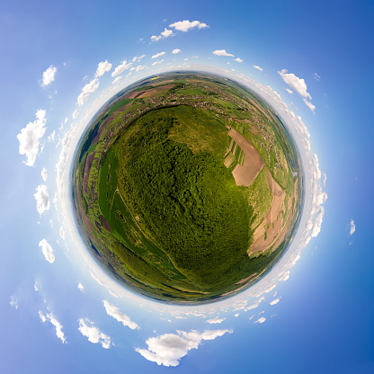 Little planet with dark mountain hills covered with green mixed pine and lush forest.
